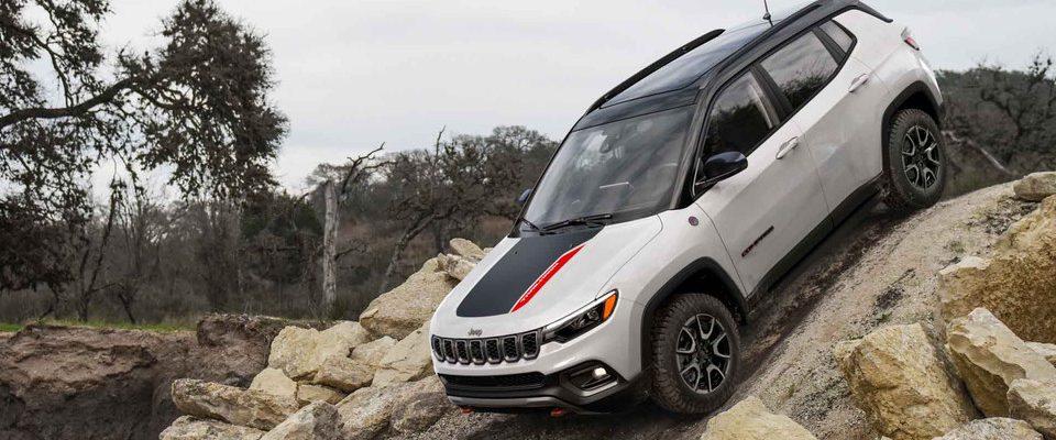 A 2026 Jeep Compass drives down a steep hill.